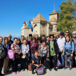 2025 Scenic Switzerland By Train + Romantic Rhine River Cruise, photo of group at Chillon Castle in Lake Geneva, Switzerland.