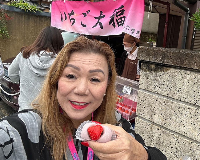 Tour Manager Jo Lelepali in Japan enjoying her strawberry mochi on the Kyoto & Osaka Mahalo Shopping Tour.